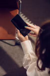 En kvinne sitter på et kontor og bruker en mobilapp på telefone