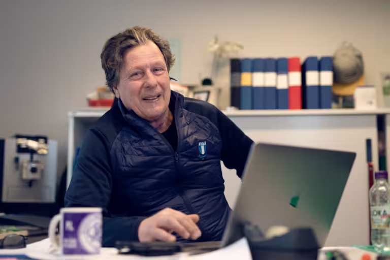 Plassleder som arbeider ved PC i byggbrakke