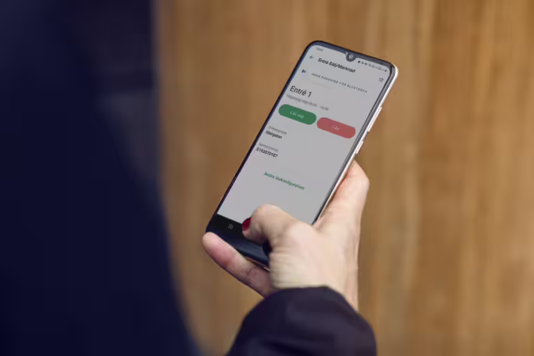 Person åpner elektronisk dørlås med Ease CheckIn-appen på mobil.