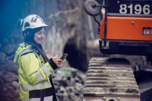 byggarbetare på byggarbetsplats med mobilapp Infobric Field