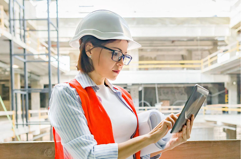 construction worker onsite looking at an ipad to check dashboards